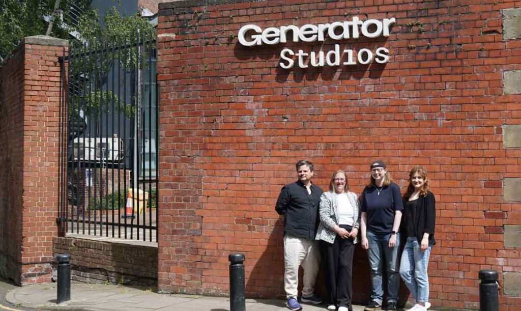 TDP - Outside Generator Studios Tiny Dragon Productions team standing outside their offices. Standing in front of a the Generator Studio's sign and big red brick wall.